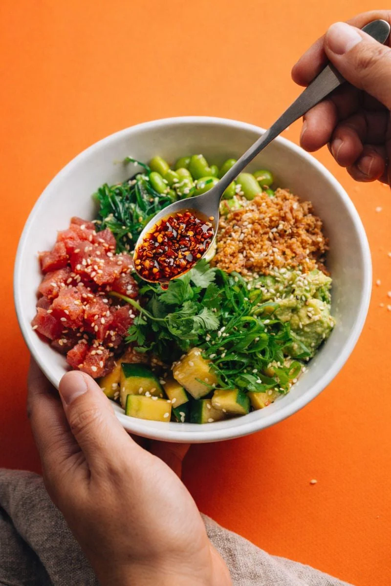 A spoonful of TINK chilli crisp above a poke bowl