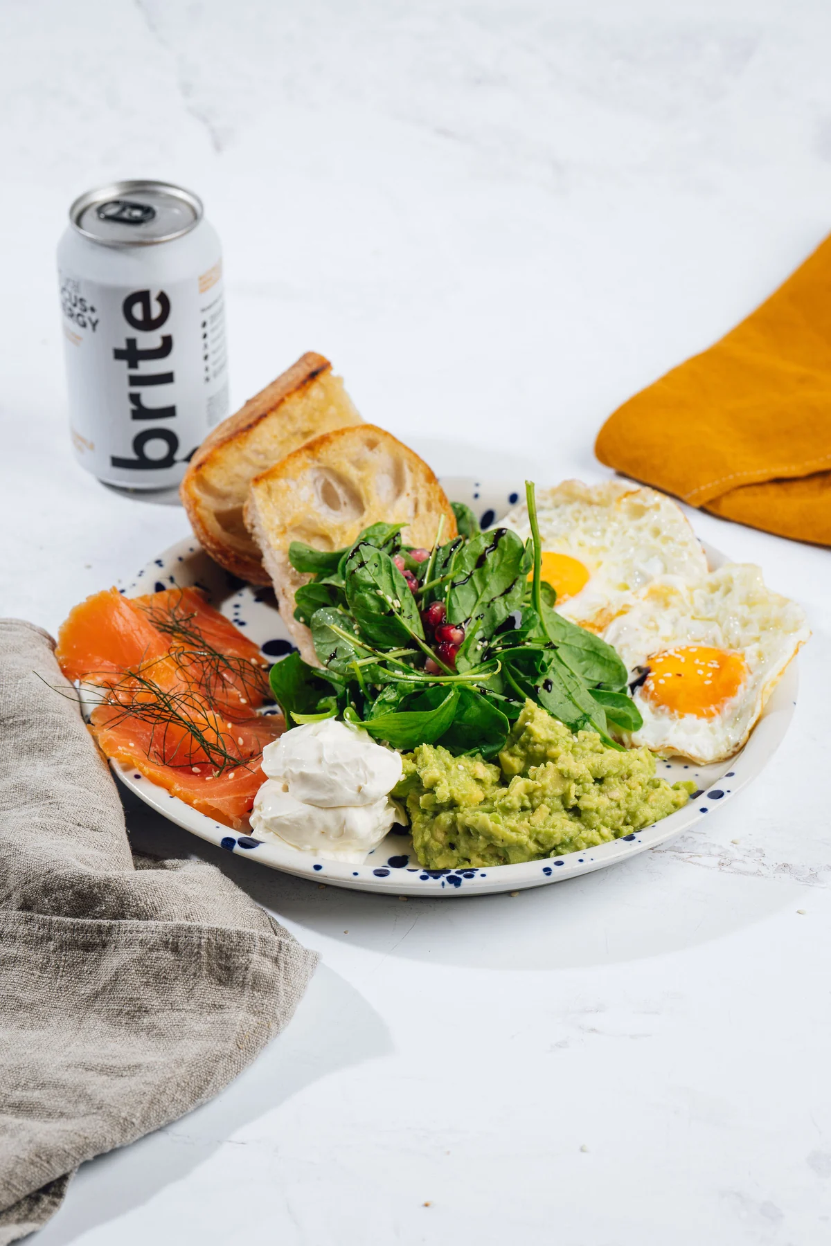 Primer breakfast plata z jajci, lososom, kruhom, avokadom in solato