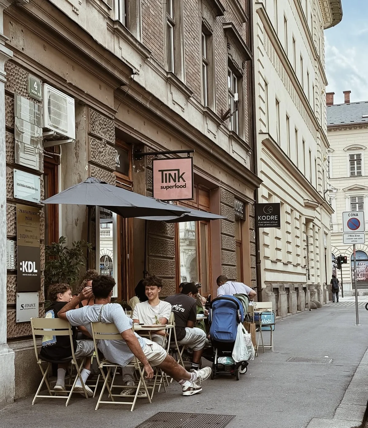 Vhod in zunanje mize TINK Superfood na Tavčarjevi 4 v Ljubljani, z roza tablo TINK